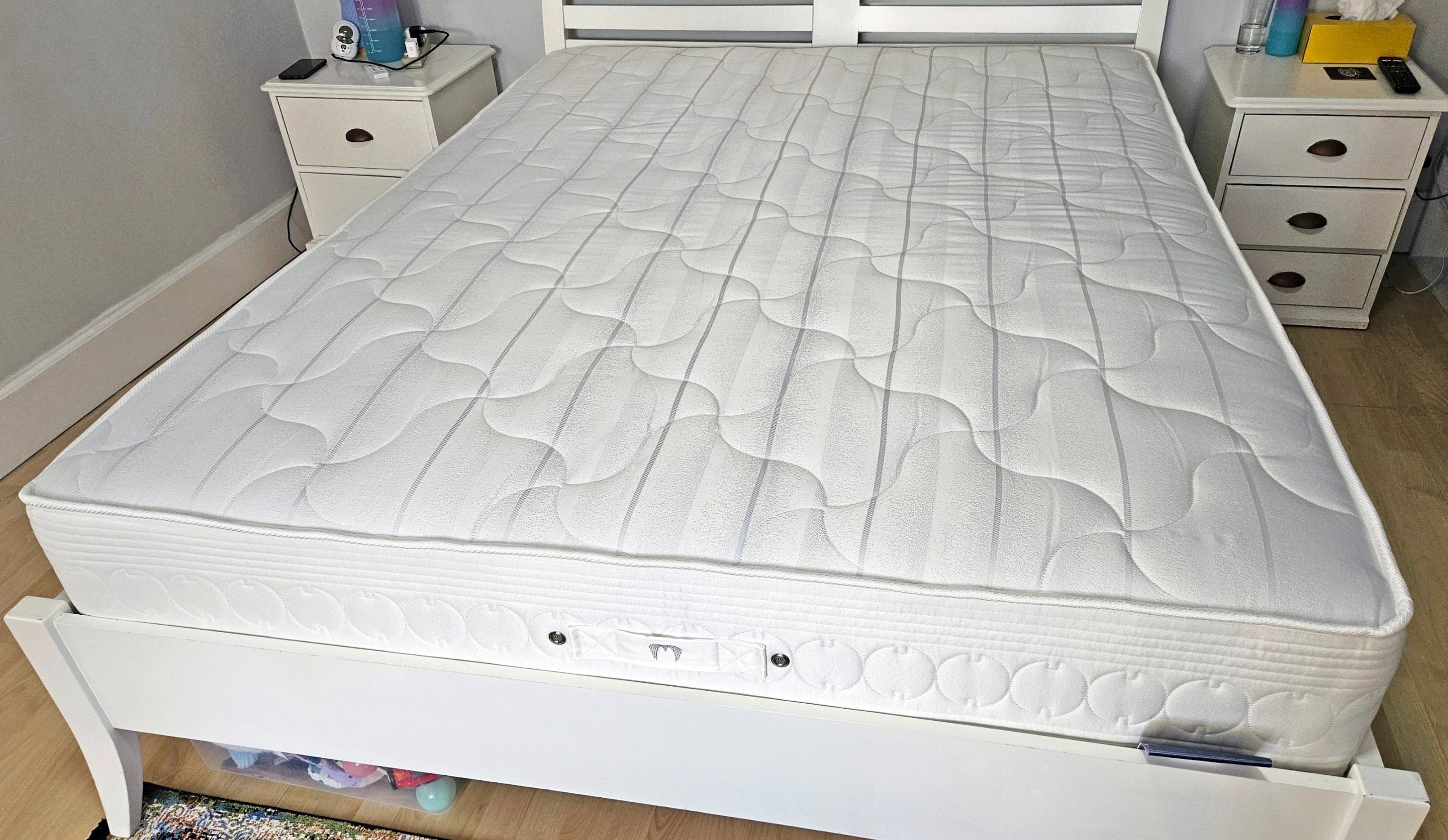 New mattress on bed frame in a bright bedroom